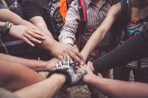 A group of diverse people putting their hands together. Image.