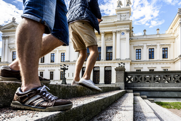 Studenter som går framför Huvuduniversitetsbyggnaden vid Lunds universitet. Bild.